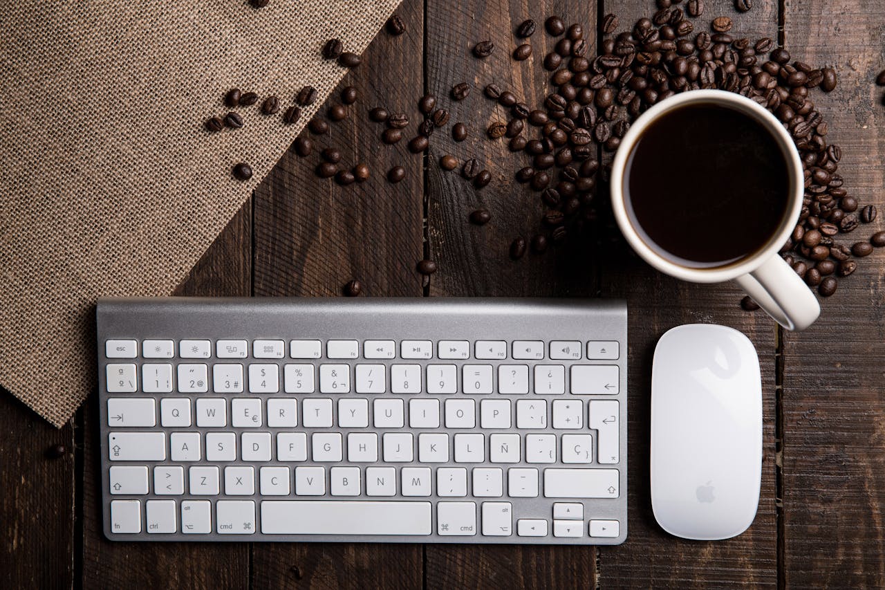 Services Top view of a coffee cup with keyboard and mouse on a rustic wooden desk.